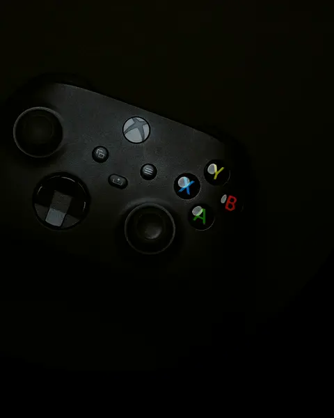 Control de consola de videojuegos negro sobre una superficie oscura